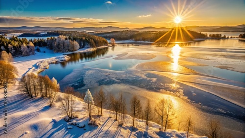 Anthropogenic Lakes in January highlighted by a burst of warm sunlight, with the frozen lake glistening like polished silver and the surrounding landscape bathed in a warm glow