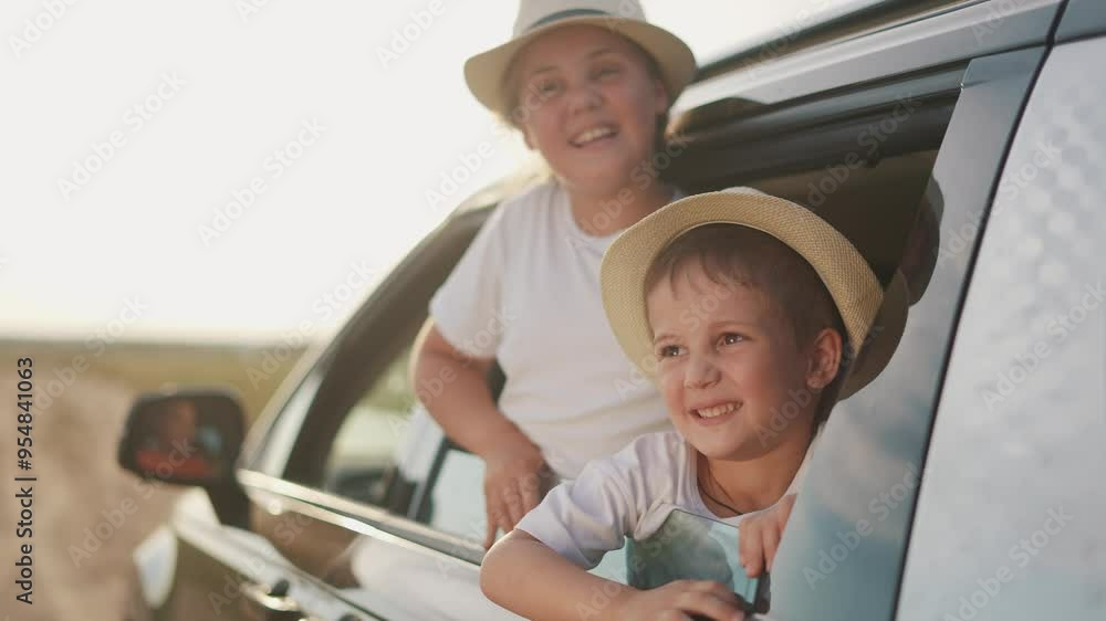 Funny children are going on a trip by car and smiling. Family kid fun concept. A family traveling in a car on vacation. Funny kids traveling through the window of a car on lifestyle vacation. Funny children are going on a trip by car and smiling. Family kid fun concept. A family traveling in a car on vacation. Funny kids traveling through the window of a car on lifestyle vacation.