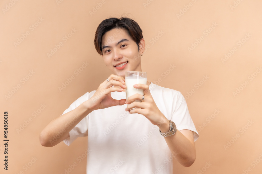A happy asian people in white shirts, holding glasses of milk and a bowl of salad, against a beige background. A happy asian people in white shirts, holding glasses of milk and a bowl of salad, against a beige background.