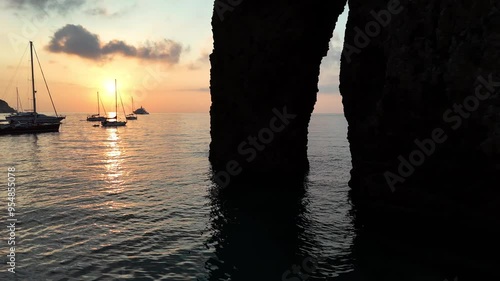 Risveglio all'alba nella baia dell'Arco Naturale dell'isola di Ponza, Italia, Mar Tirreno, Mediterraneo.
Le barche ancorate nella baia più suggestiva di Italia in una mattina d'estate col sole giallo. photo