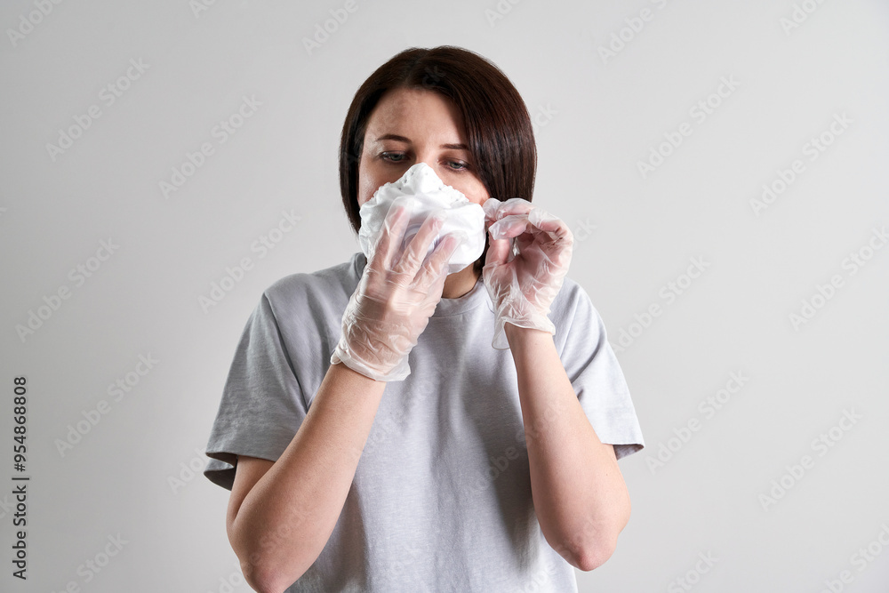 Young woman wearing face mask for protection from coronavirus over grey background with copy space Young woman wearing face mask for protection from coronavirus over grey background with copy space