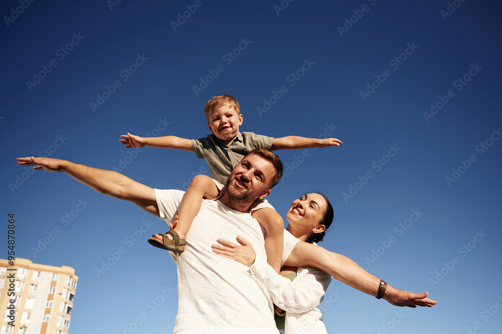 Mother and father are with son outdoors on the field Mother and father are with son outdoors on the field