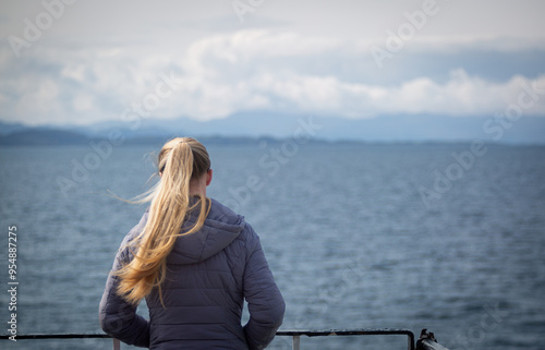 Young Caucasian female in her 20's on a Scottish ferry from the mainland to the remote Scottish isles admiring the landscape  photo