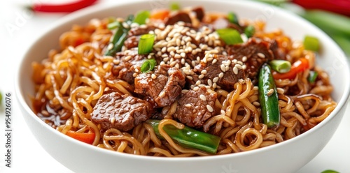 A Bowl of Beef and Noodles with Sesame Seeds and Green Onions