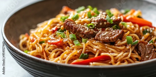 Close-up of a Bowl of Beef Lo Mein with Sesame Seeds and Green Onions