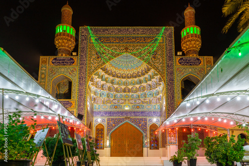 The Iranian Mosque (Imam Hussein Mosque) entrance in Dubai, with colorful tiles, Persian style facade and UAE national flag colors illuminations, night view. photo