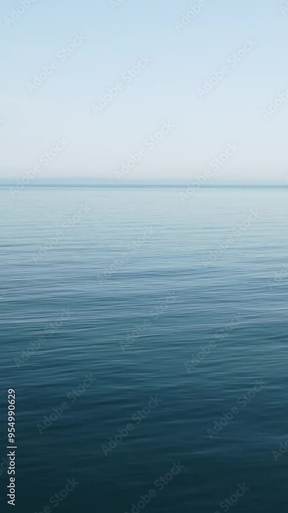 Vertical aerial view on sea water surface, camera flies over clear sea water. Sun glare. Abstract nautical summer ocean nature. Holiday, vacation and travel concept. Nobody. Weather and climate change Vertical aerial view on sea water surface, camera flies over clear sea water. Sun glare. Abstract nautical summer ocean nature. Holiday, vacation and travel concept. Nobody. Weather and climate change
