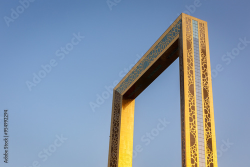 Dubai Frame ornamental golden facade, architectural landmark of Dubai, the largest frame in the world against clear blue sky, golden hour.