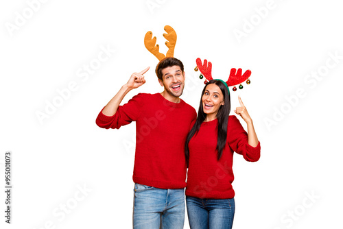 Portrait of charming spouses point at their deer handband reccomend product wear red pullover denim jeans isolated over yellow background photo