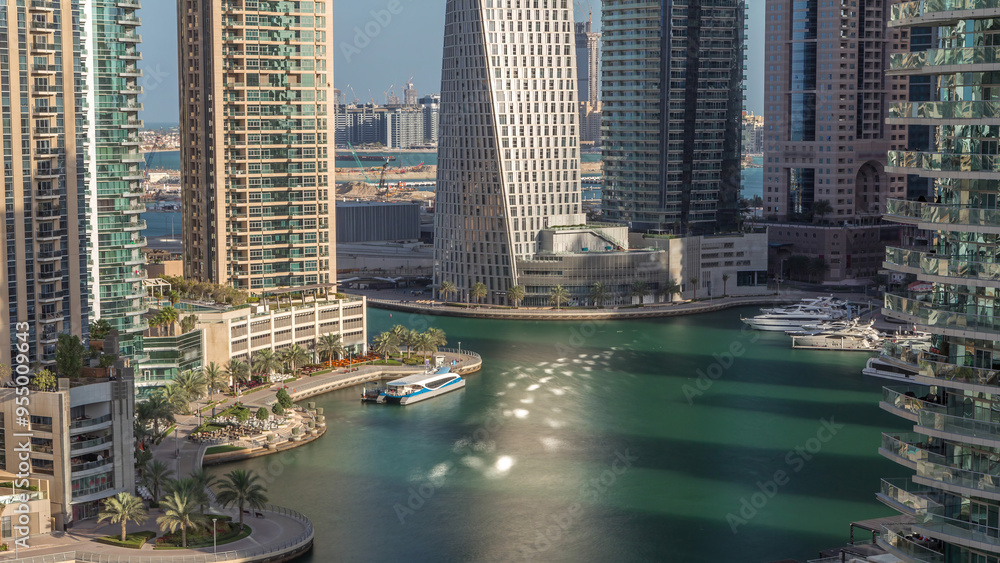 Fototapeta premium Aerial view of Dubai Marina residential and office skyscrapers with waterfront timelapse