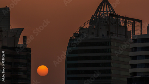 Sunrise between residential and office buildings in JLT district aerial timelapse in Dubai, UAE. photo