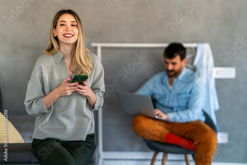 Young woman wearing sweater using smartphone at home, communication and social network concept,