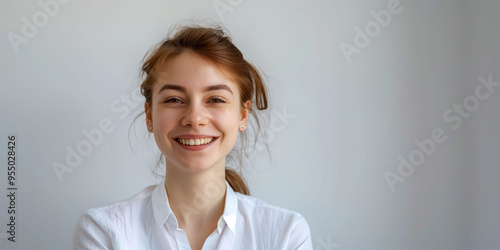 Smiling young woman in white shirt against neutral background