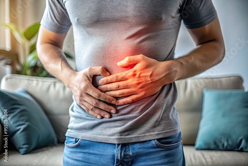 Obraz na płótnie A clenched hand grasps a tender abdomen, as a faintly visible outline of a couch in the blurred background suggests a day ruined by digestive discomfort. w salonie
