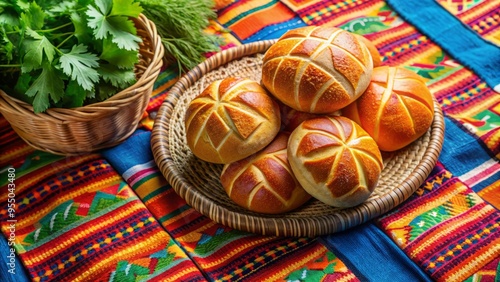 Freshly baked traditional Mexican bread, known as Bolillo, sits on a vibrant woven blanket, surrounded by colorful tiles and fresh cilantro, evoking a festive atmosphere.