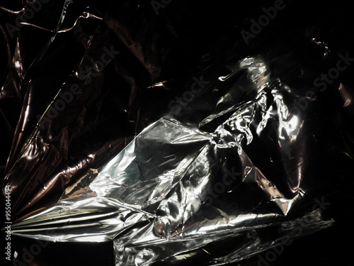 Silver foil in the dark for a mysterious abstract background. photo