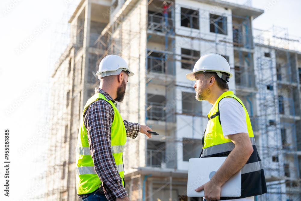 Architect and contractor working on building in construction site. Two Professional Architects Engineer Working on Personal laptop computer at house construction site