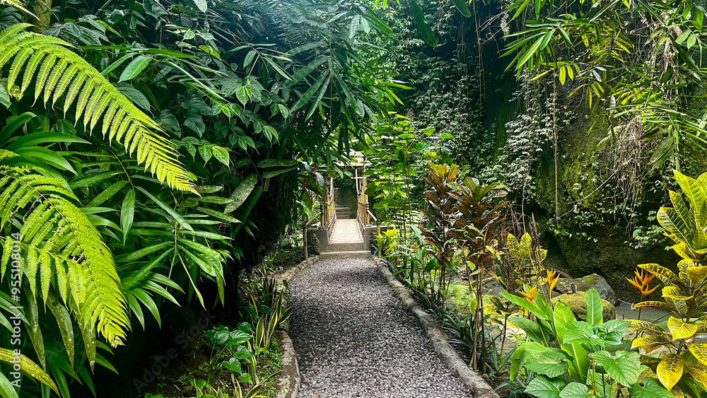 Fototapeta premium Stone path leading through the lush jungle near Tibumana Waterfall - Bali, Indonesia