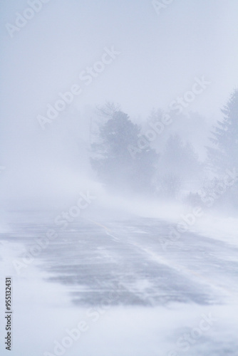 Fierce blizzard covers a strip of road with snow. Winter road conditions.