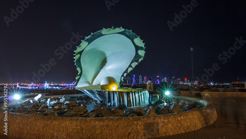 A fountain featuring an oyster with a gigantic pearl inside night timelapse hyperlapse with the Doha skyline behind it photo