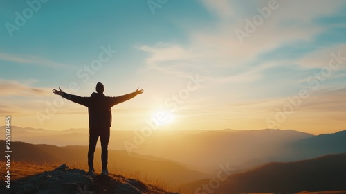 A person stands on a mountain peak, embracing the sunrise with open arms, symbolizing freedom and new beginnings. photo