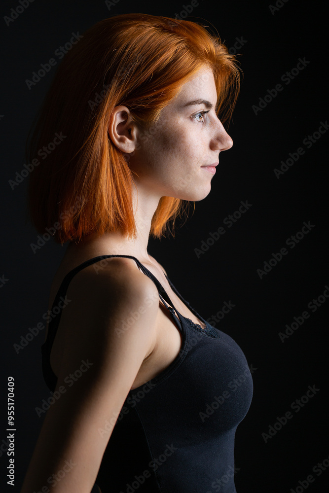 Cute red-haired girl, studio portrait on a black background. Cute red-haired girl, studio portrait on a black background.