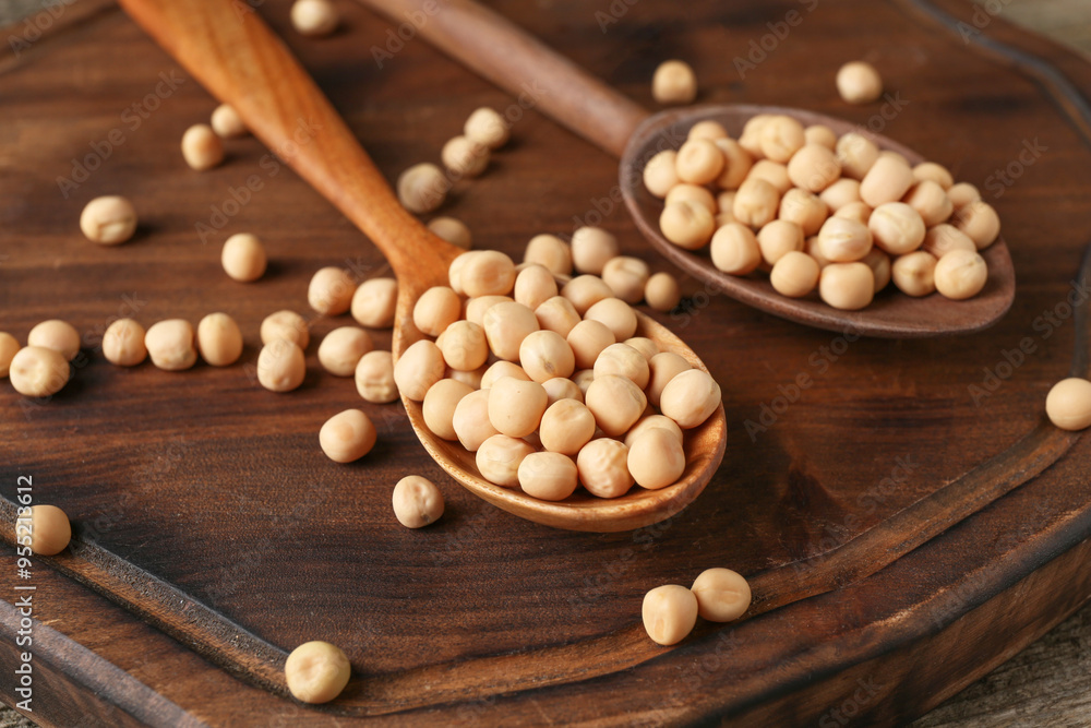 Spoons with dried peas on wooden table, closeup Spoons with dried peas on wooden table, closeup