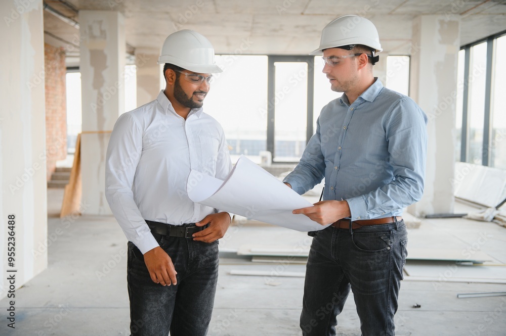 Indian and European construction workers together at a construction site Indian and European construction workers together at a construction site