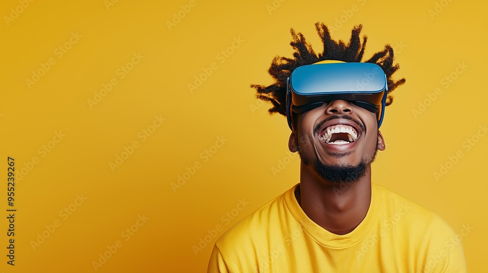 A man with dreadlocks is wearing a yellow shirt and smiling while wearing a virtual reality headset. Concept of excitement and fun, as the man is fully immersed in the virtual world A man with dreadlocks is wearing a yellow shirt and smiling while wearing a virtual reality headset. Concept of excitement and fun, as the man is fully immersed in the virtual world