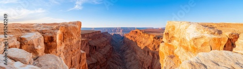 Stunning panoramic view of a canyon at sunset, featuring vibrant colors and dramatic rock formations under a clear blue sky.