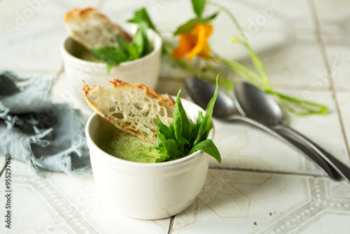 ramekins with spinach cream soup on the table photo