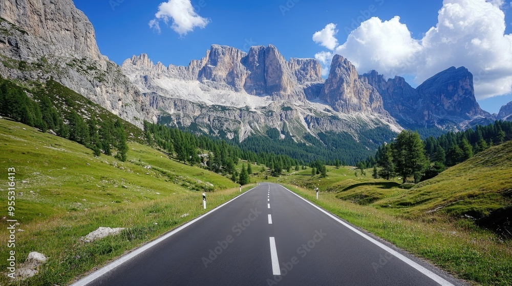 A scenic view of an empty road cutting through Venegia Valley, with towering dolomite mountains in the distance. A scenic view of an empty road cutting through Venegia Valley, with towering dolomite mountains in the distance.