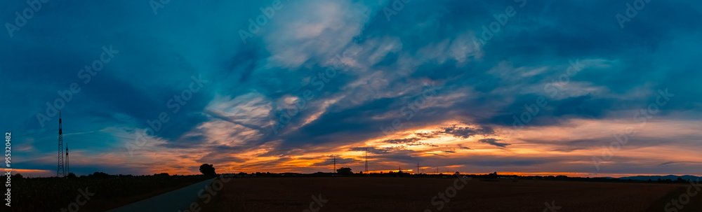 Sunset with a dramatic sky and overland high voltage lines near Tabertshausen, Aholming, Deggendorf, Bavaria, Germany Sunset with a dramatic sky and overland high voltage lines near Tabertshausen, Aholming, Deggendorf, Bavaria, Germany