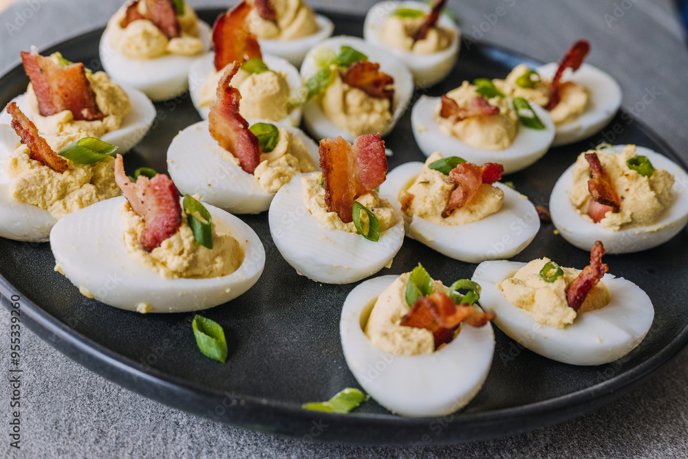 Deviled eggs garnished with bacon and green onion Deviled eggs garnished with bacon and green onion