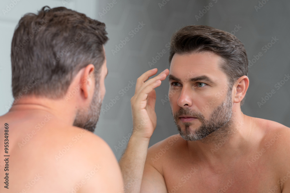 Naklejka premium Beauty man use moisturizing face balm for healthy skin, male skincare concept. Male beauty and skin care portrait. Healthy clean face after shaving, facial treatment, skincare concept.