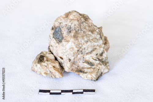 Photos Plagioclase Feldspar and biotite pegmatite on a white background with a 5cm scal
