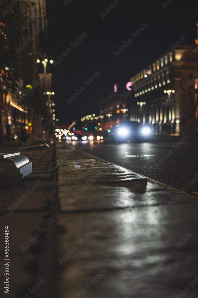Fototapeta premium The night city of Minsk. Cars in the distance are driving along the avenue