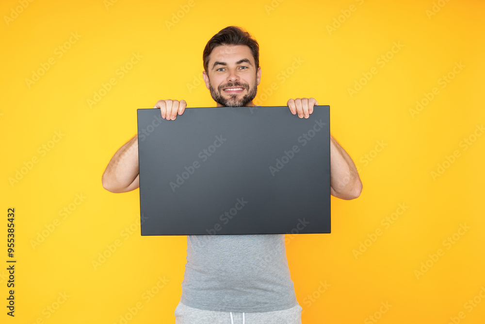 Happy attractive handsome smiling middle aged man showing promo blank board on studio background. Blank signboard with copyspace. Advertisement concept. Board with copy space, blank mockup. Happy attractive handsome smiling middle aged man showing promo blank board on studio background. Blank signboard with copyspace. Advertisement concept. Board with copy space, blank mockup.