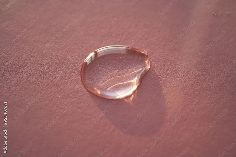 Beautiful volumetric drop of cosmetic product on a pink background. Beautiful volumetric drop of cosmetic product on a pink background.