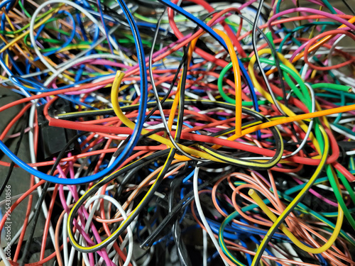 In the garage, after the work of an auto electrician, there are a lot of thin wires, tangled colored wires, intertwined with each other photo