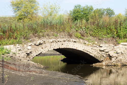 An ancient bridge on an abandoned road. photo