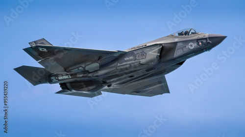 Dynamic photo of a F-35 military jet in flight against a clear blue sky, showcasing the advanced technology and sleek design of this aircraft. Perfect for aviation enthusiasts, defense industry, and d