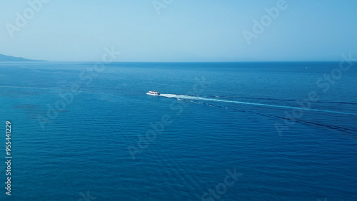 Vertical Aerial View of Deep Blue Sea Water with Yacht and Boat Leaving White Foamy Trail