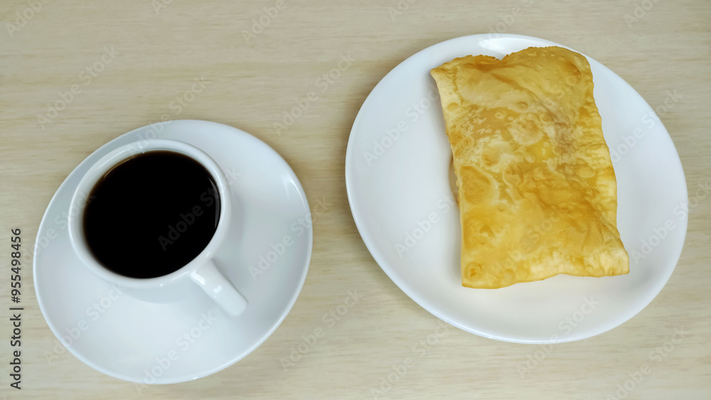 One Brazilian pastry called pastel on the plate and cup of coffee on the table with copy space
One Brazilian pastry called pastel on the plate and cup of coffee on the table with copy space