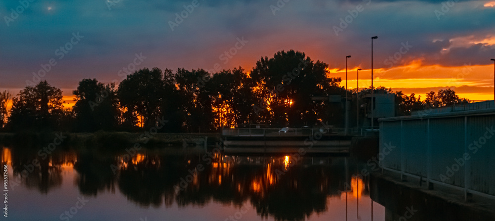 Summer sunset with reflections near Plattling, Isar, Deggendorf, Bavaria, Germany Summer sunset with reflections near Plattling, Isar, Deggendorf, Bavaria, Germany