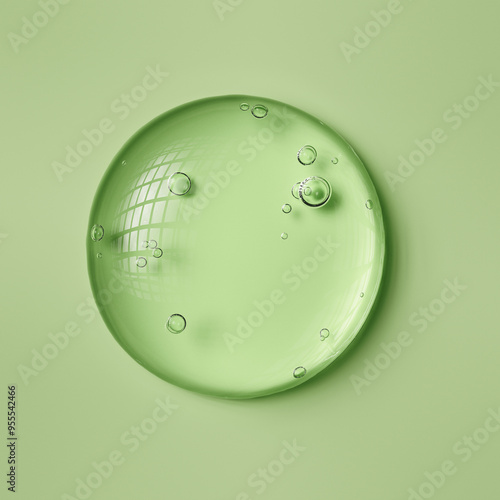 Vászonkép Round drop of transparent cosmetic gel on a green background