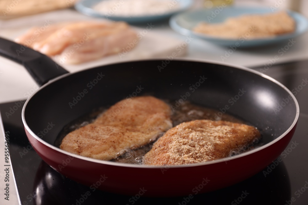 Schnitzels cooking in frying pan on stove, closeup Schnitzels cooking in frying pan on stove, closeup