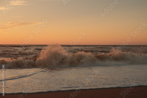 Sunset at sea during a storm. Coast with waves in sea on sunset. Waves in sea during storm and wind. Wave from the sea goes on land to the beach. Splashing Waves, Seaside.