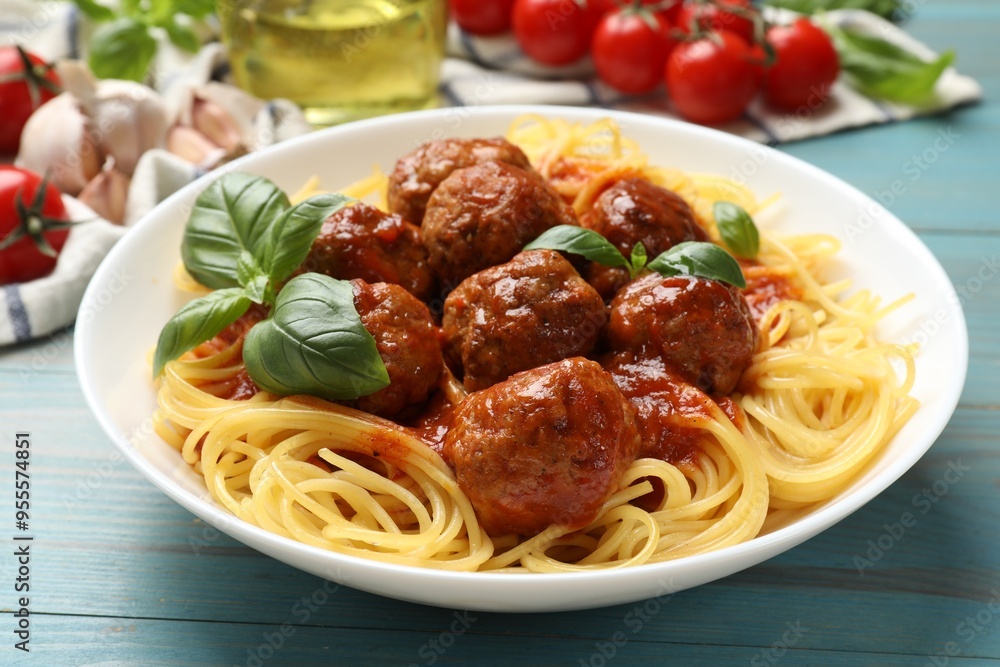 Delicious pasta with meatballs and ingredients on blue wooden table, closeup Delicious pasta with meatballs and ingredients on blue wooden table, closeup