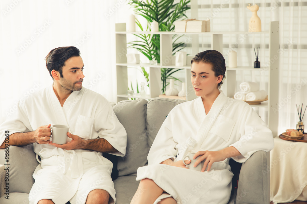 Beauty or body treatment spa salon vacation lifestyle concept with couple wearing bathrobe relaxing with drinks in luxurious hotel spa or resort room. Vacation and leisure relaxation. Quiescent Beauty or body treatment spa salon vacation lifestyle concept with couple wearing bathrobe relaxing with drinks in luxurious hotel spa or resort room. Vacation and leisure relaxation. Quiescent